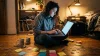 Femme travaillant sur laptop entourée de notes colorées